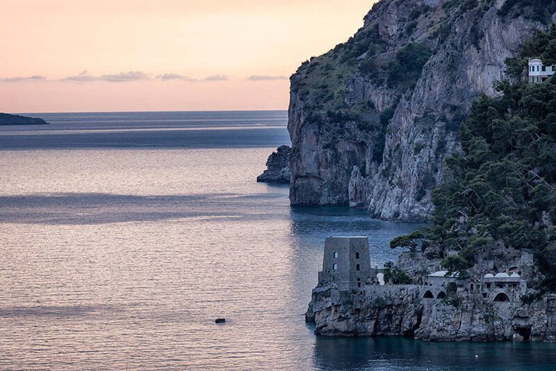 Afternoon view of clear water and a rocky island in the distance